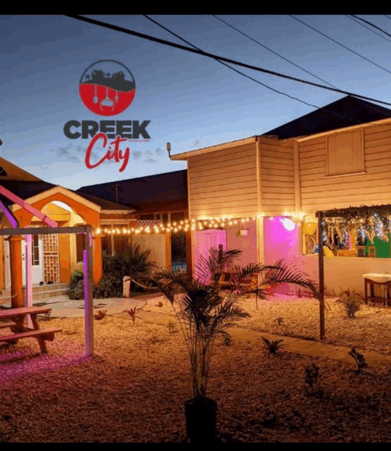 a house with a sign that says creek city is lit up at night