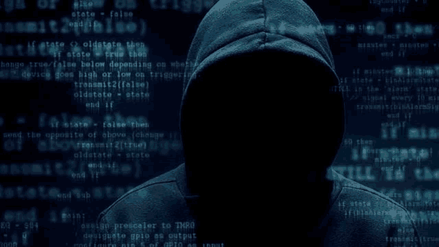 a person in a hooded sweatshirt is standing in front of a computer screen filled with lots of code .