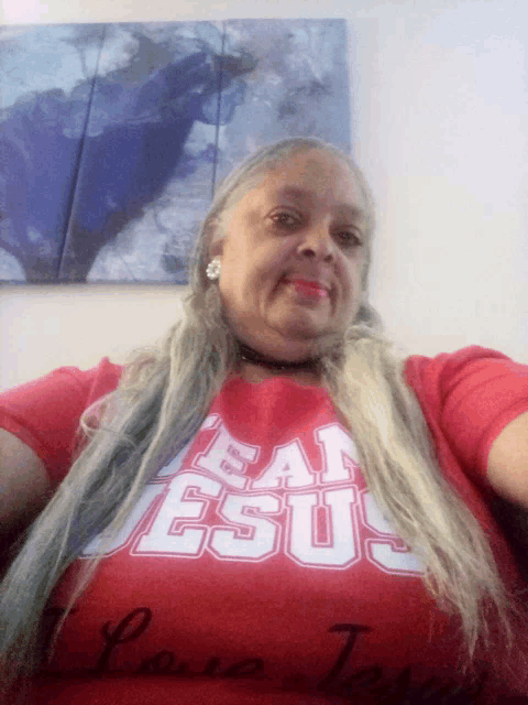 a woman wearing a red shirt that says eat jesus on it