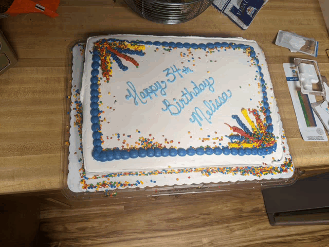 a birthday cake with blue frosting and sprinkles says happy 37th birthday melissa