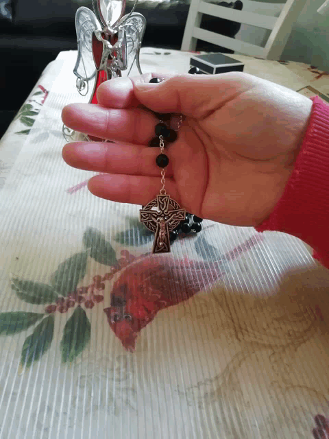 a person holding a rosary in their hand