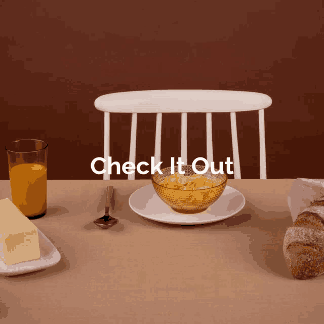 a table with a bowl of cereal a glass of orange juice butter and bread and the words check it out above it