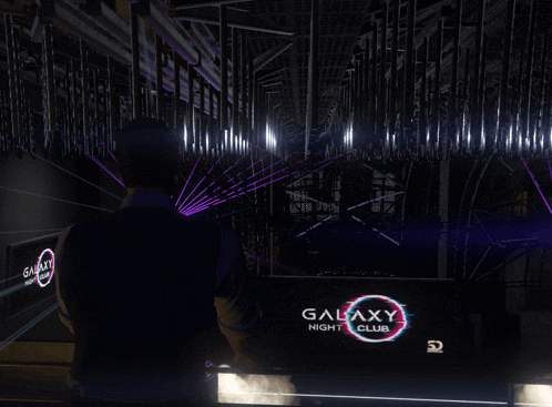 a man standing in front of a galaxy night club sign