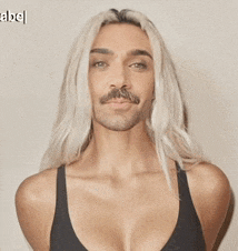 a man with a mustache is wearing a black tank top