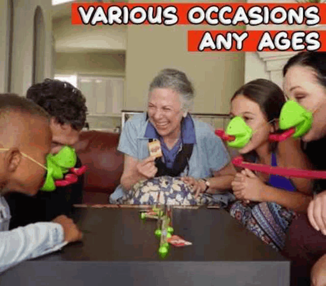 a group of people are sitting around a table playing a game with frogs on their faces .