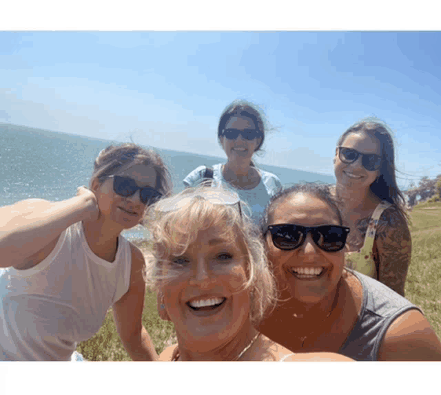 a group of women wearing sunglasses pose for a photo