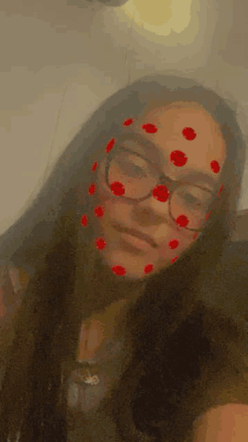 a girl wearing glasses and a mask with red hearts on her face