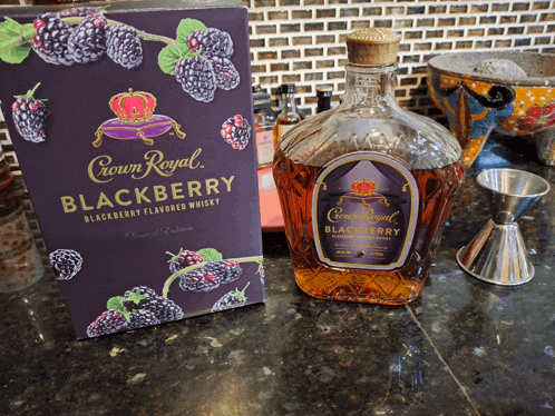 a bottle of crown royal blackberry flavored whisky next to its box