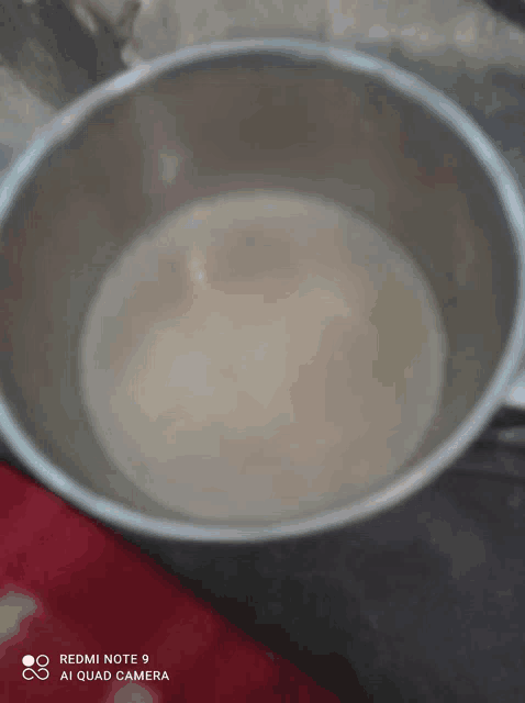 a pot of liquid is being photographed on a redmi note 9