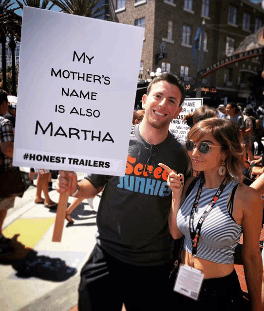 a man and a woman holding a sign that says my mother 's name is also martha