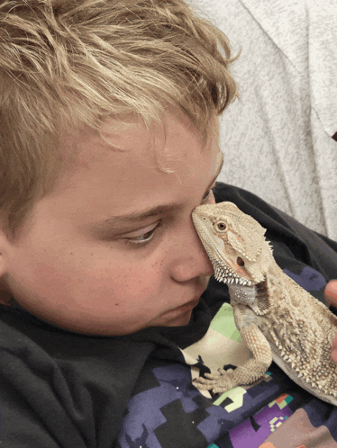 a boy with a lizard on his face and a minecraft shirt