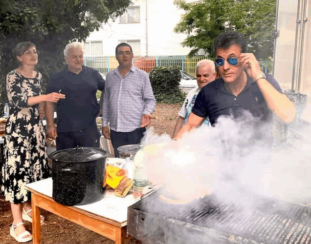 a man wearing sunglasses is standing in front of a grill