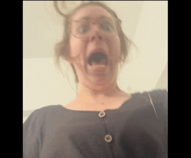 a woman wearing glasses and a black shirt is making a funny face