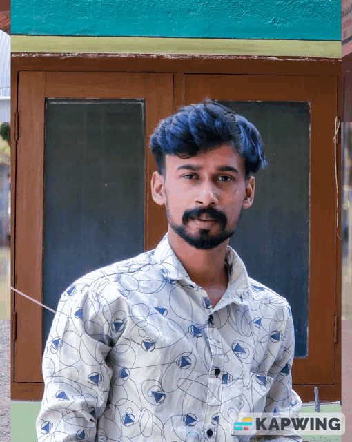 a man with blue hair is standing in front of a window with kapwing on the bottom right