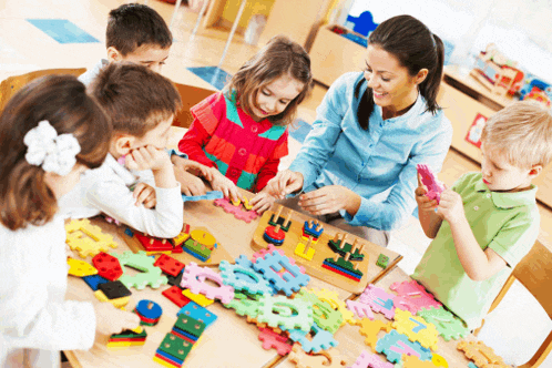 a group of children are playing with puzzles and a woman is smiling at them