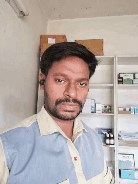 a man stands in front of a shelf with a box that says aroid