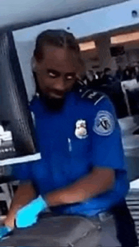 a security guard is wearing blue gloves and a blue shirt .