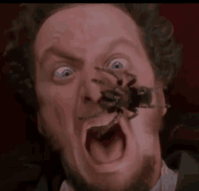 a close up of a man 's face with a spider on it .