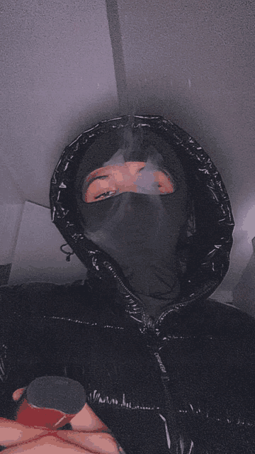 a man wearing a ski mask is smoking