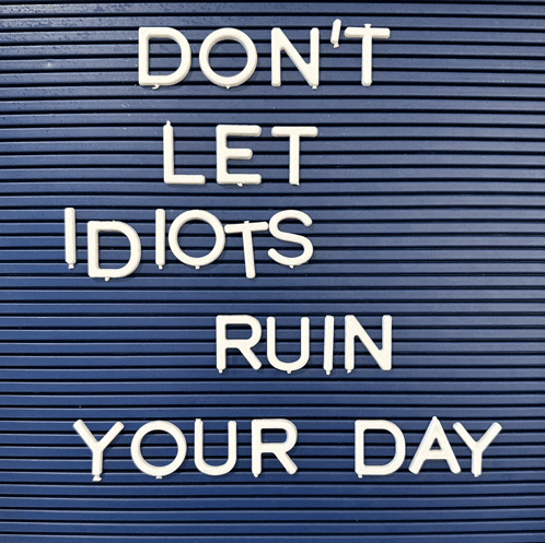 a sign that says " don t let idiots ruin your day "