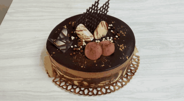 a chocolate cake with chocolate sprinkles and nuts on top