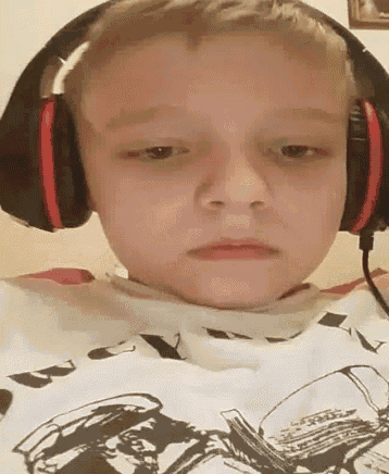 a young boy wearing headphones and a t-shirt with a picture of a man on it .