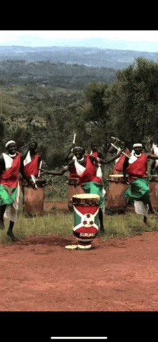 a group of people are playing drums in a field