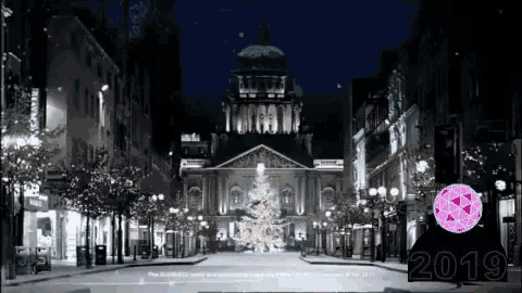 a black and white photo of a christmas tree in front of a building with the year 2019 on the bottom