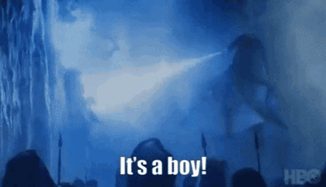 a crowd of people standing in front of a waterfall with the words `` it 's a boy '' written on the screen .