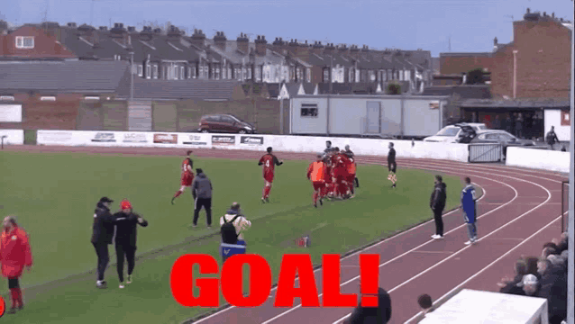 a group of soccer players on a field with the word goal in red