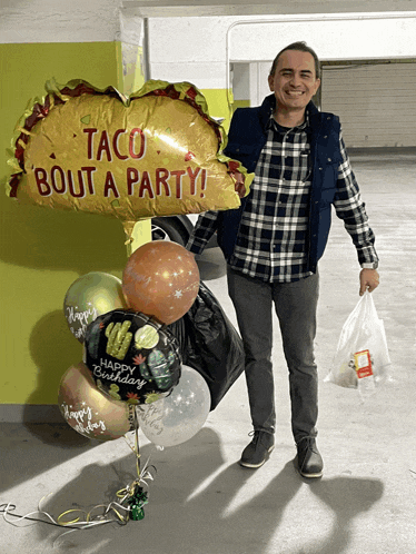 a man is holding a bag of food and a taco bout a party balloon in front of him