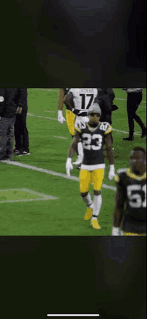 a green bay packers player wearing number 23 stands on the field