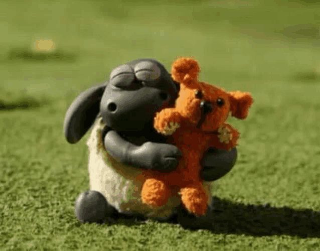 a sheep is holding a stuffed animal in its arms .