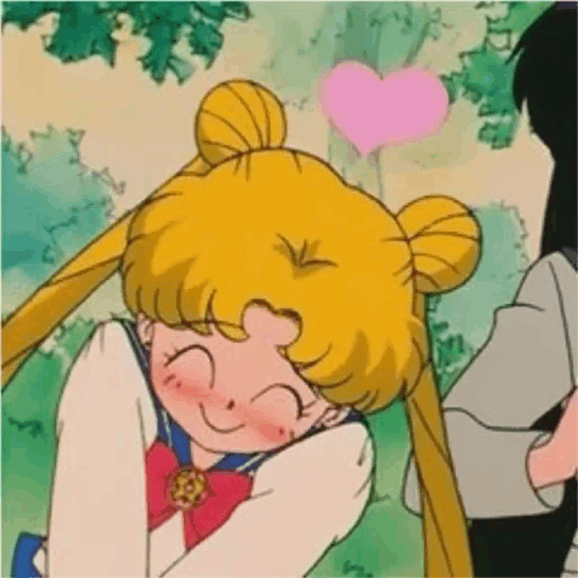 sailor moon is smiling and hugging a man with a heart on her head .