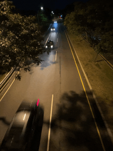 cars are driving down a highway at night with a red arrow pointing to the right