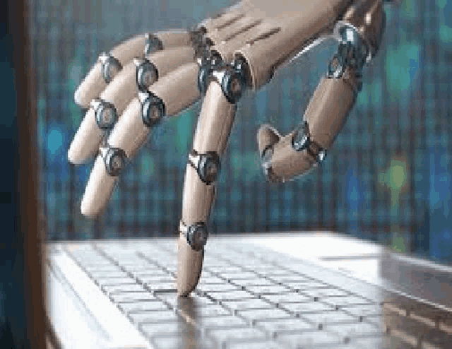 a robot hand is typing on a laptop computer .