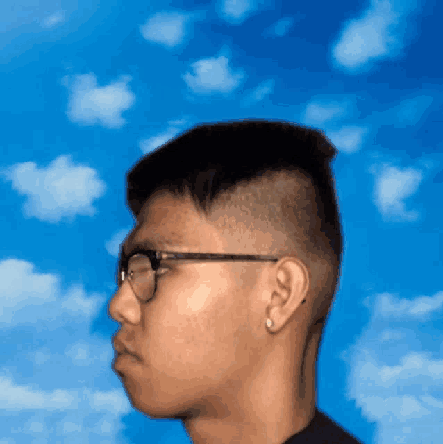 a man wearing glasses and earrings is looking at the sky