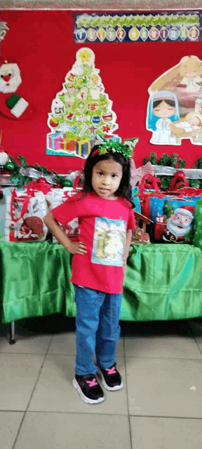 a little girl standing in front of a christmas display