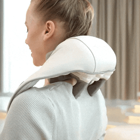 a woman is using a white massager on her neck