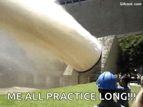 a man in a blue hard hat is standing in front of a large pipe that is blowing smoke .