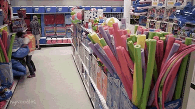 a store aisle filled with lots of colorful foam noodles .