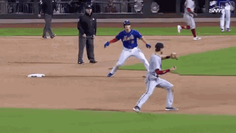 two baseball players are playing a game of baseball on a field . one player is wearing a mets jersey .