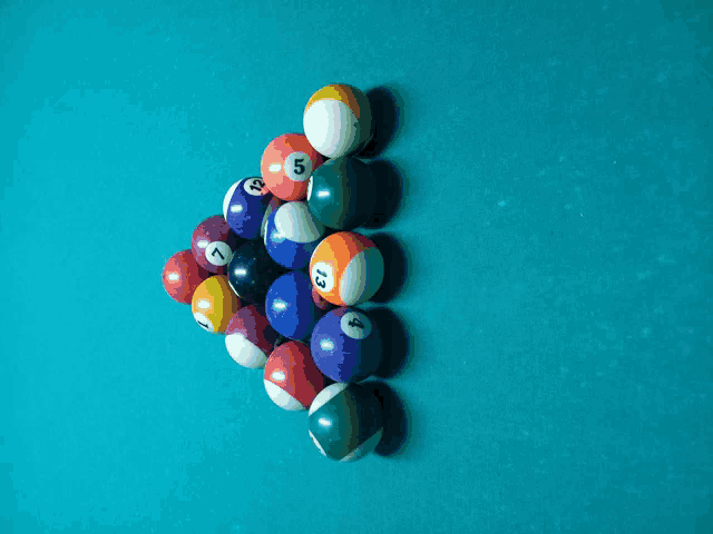 pool balls are arranged in a triangle on a pool table including the number 13