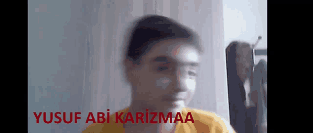 a blurry picture of a boy with the name yusuf abi karizmaa written on the bottom