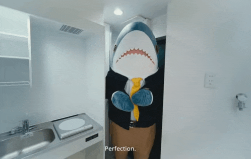 a stuffed shark in a kitchen with perfection written on the bottom right