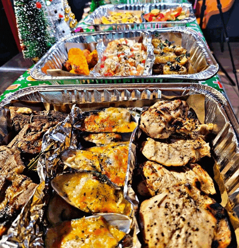 several trays of food are lined up on a table