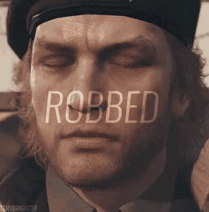 a close up of a man 's face with the word robbed behind him