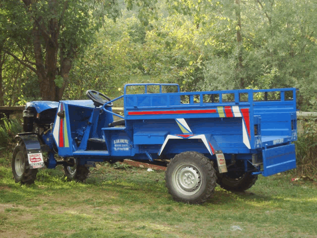 a blue tractor with a trailer attached to it has a sticker on the back that says ' amasya '