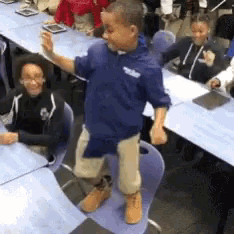 a boy wearing a blue shirt with the word tribe on it stands in front of a group of children