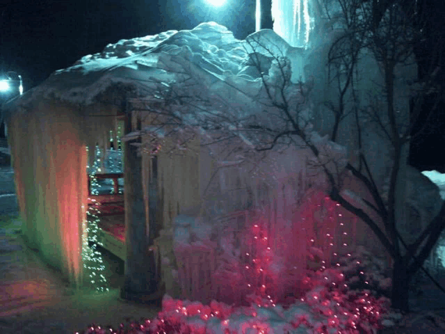 a large ice sculpture is lit up at night with red lights